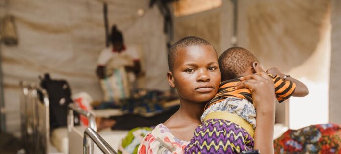 Rosine, de 15 anos, segura sua sobrinha dentro da unidade de isolamento e tratamento de mpox apoiada pelo Unicef no Hospital Kavumu, na província de Kivu do Sul, República Democrática do Congo, em 14 de setembro de 2024