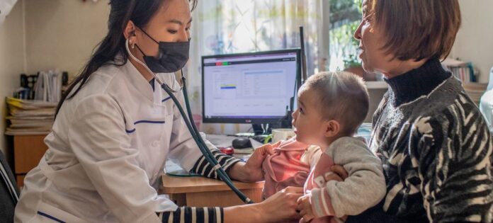 Uma menina de 18 meses recebe suas vacinas de rotina na infância no Quirguistão