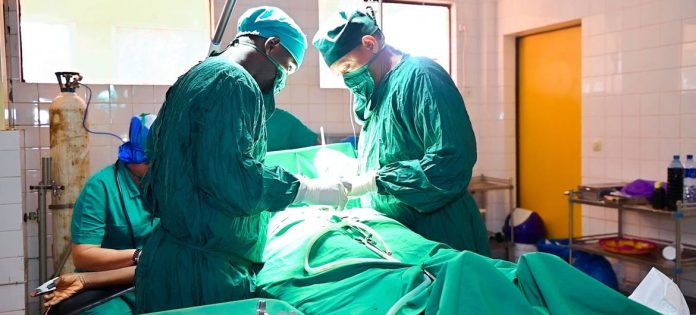 Centro cirúrgico do Hospital Regional Labé, na Guinéa, uma equipe realiza uma cirurgia em uma mulher com fístula obstétrica